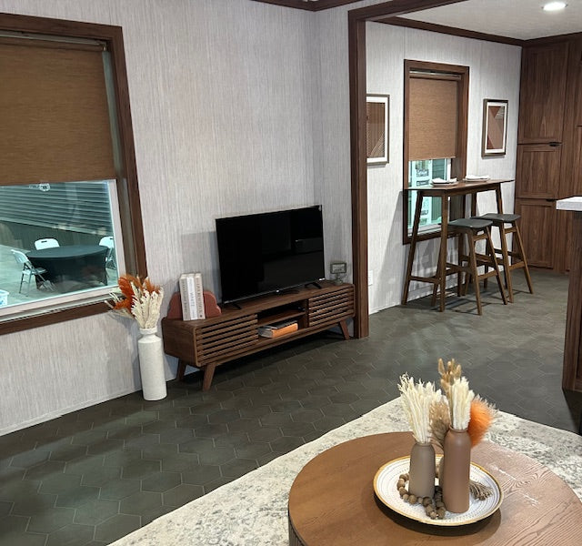 Living room with a TV, decorative items, and a view of a car outside the window.