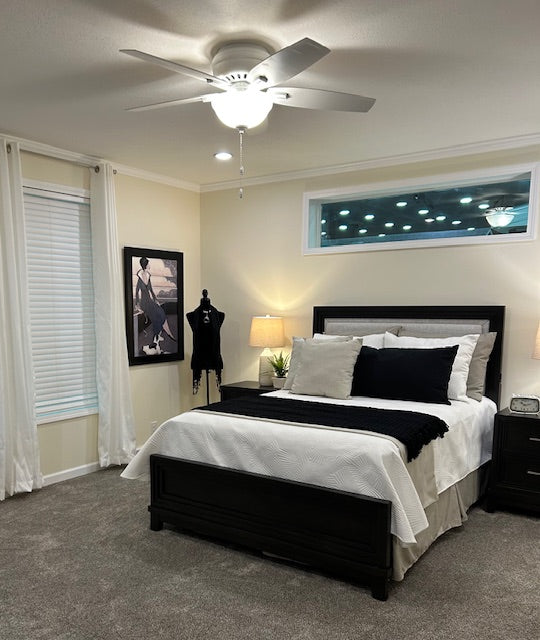 Modern bedroom with a bed, nightstands, and decorative items.