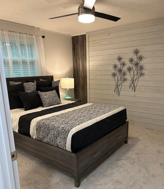 Bedroom with a bed, lamp, and decorative wall art.
