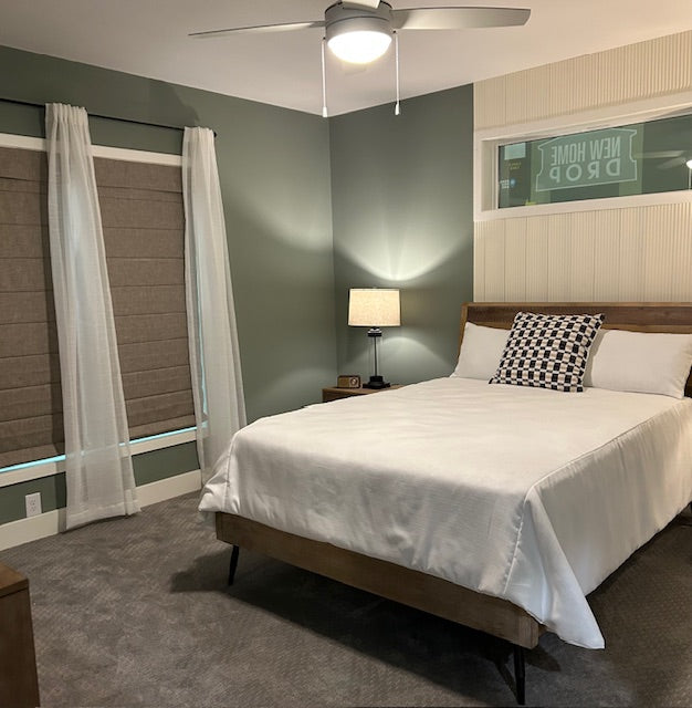 Modern bedroom with a bed, nightstand, and lamp in a home setting.